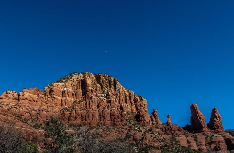 Crescent Moon over a setting sun on red rocks - Things to do in Sedona