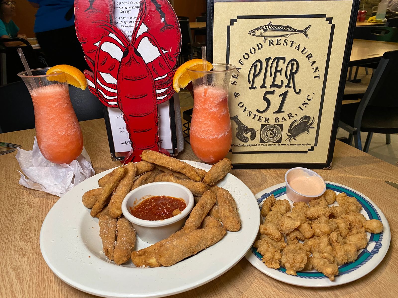 peach daquiris adorned with orange slice with fried eggplant and marinara and fried alligator with fry sauce. Best New Orleans food to eat. 