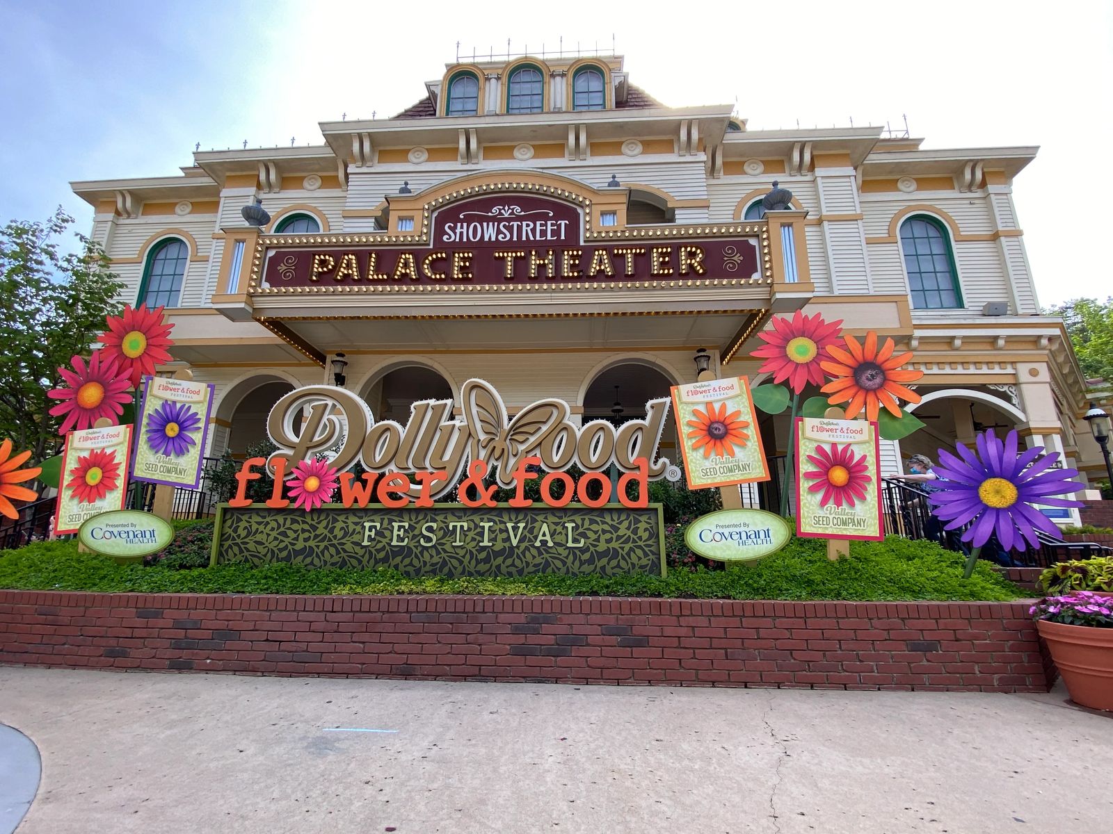 Guide to Dollywood, the Dollywood sign with colorful flower and food festival sign