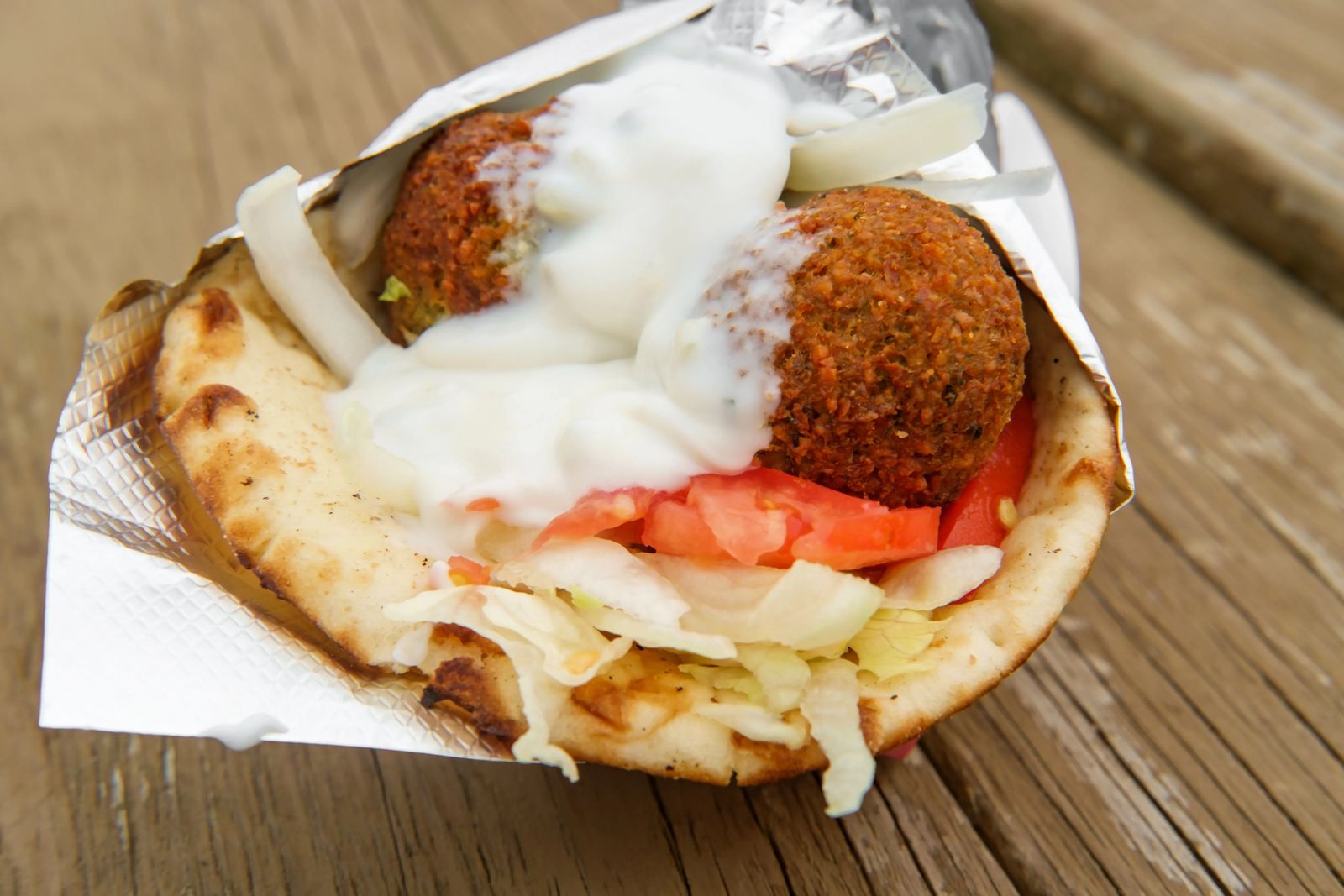 Fresh and healthy falafel with tzatziki tomato red onion and iceberg lettuce in pita bread