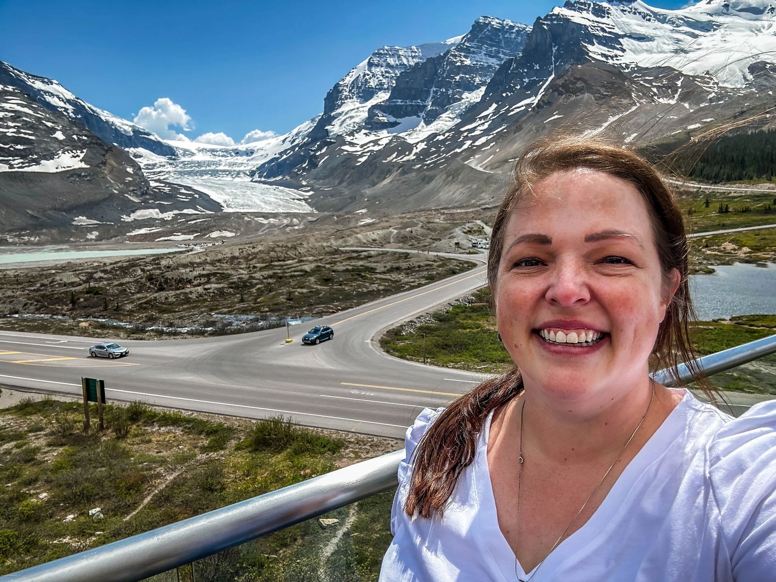 Woman in front of Athabasca Glacier a good distance from the Glacier on a viewing platform