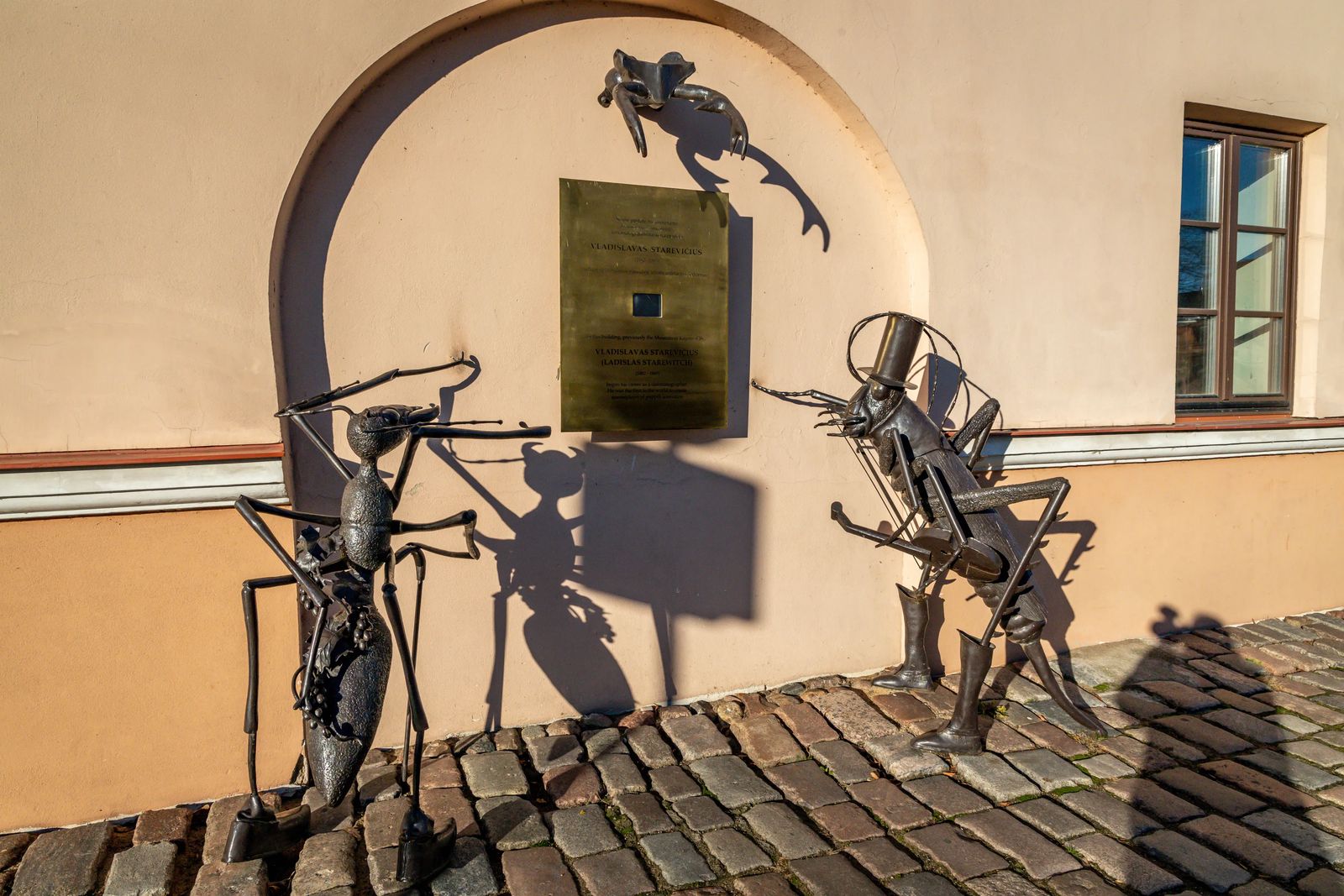 Things to do in Kaunas - metal statues of bugs looking at a placard