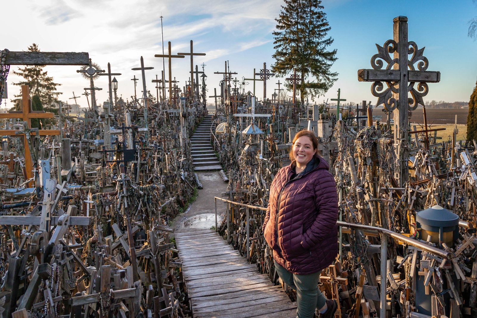 Janiel Standing on wooden walkway among thousands of wooden crosses