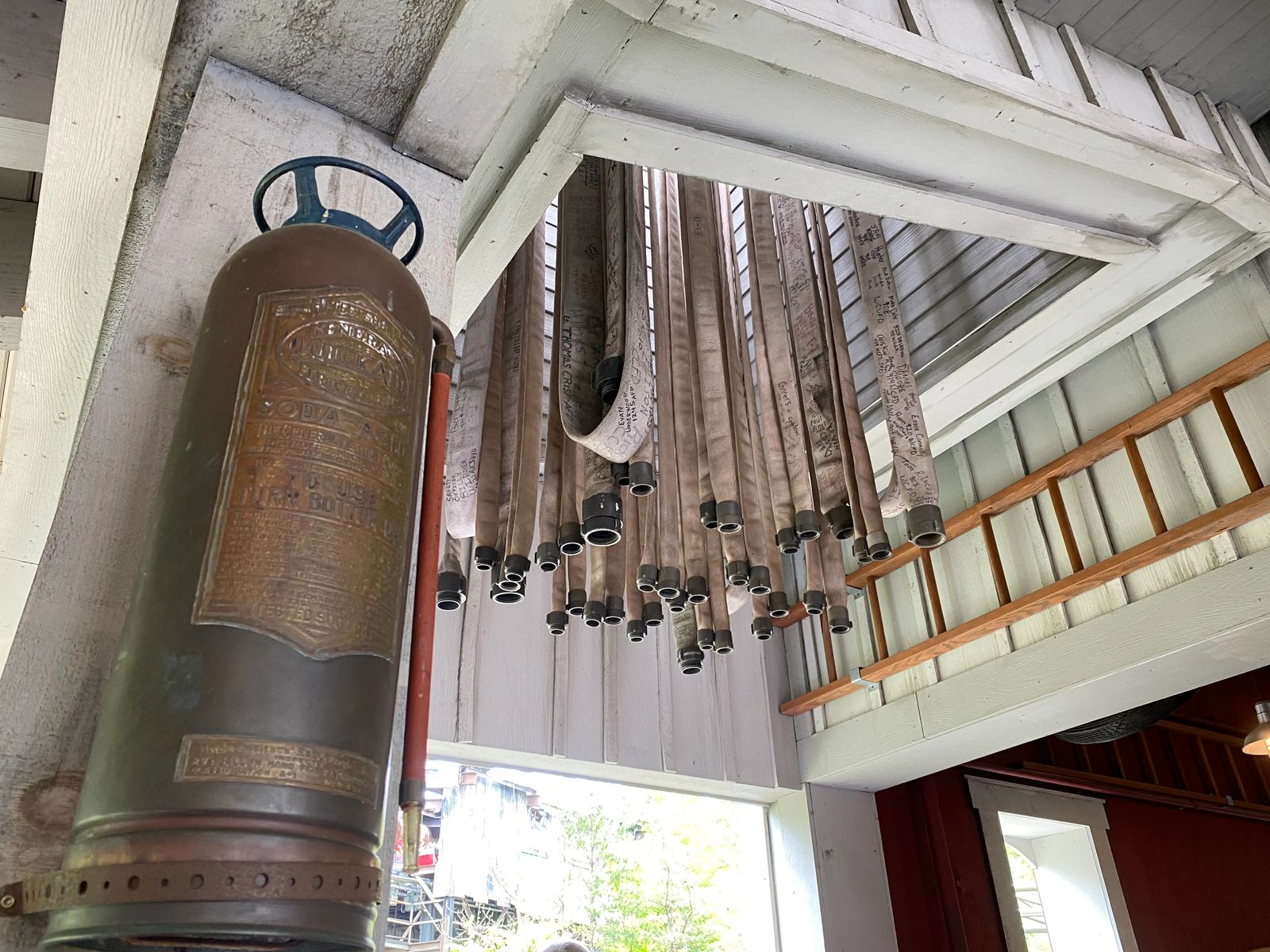 Firehoses signed with names dangle from the ceiling, guide to dollywood