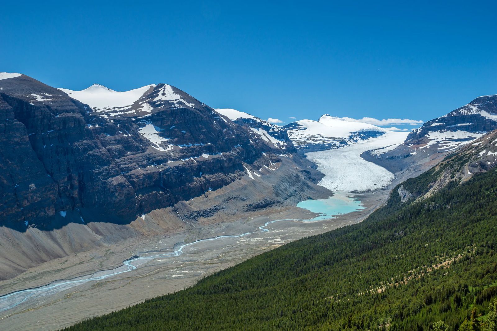 A River of snow and ice in the distance that leads to a blue river, this is Saskatchewan Glacier