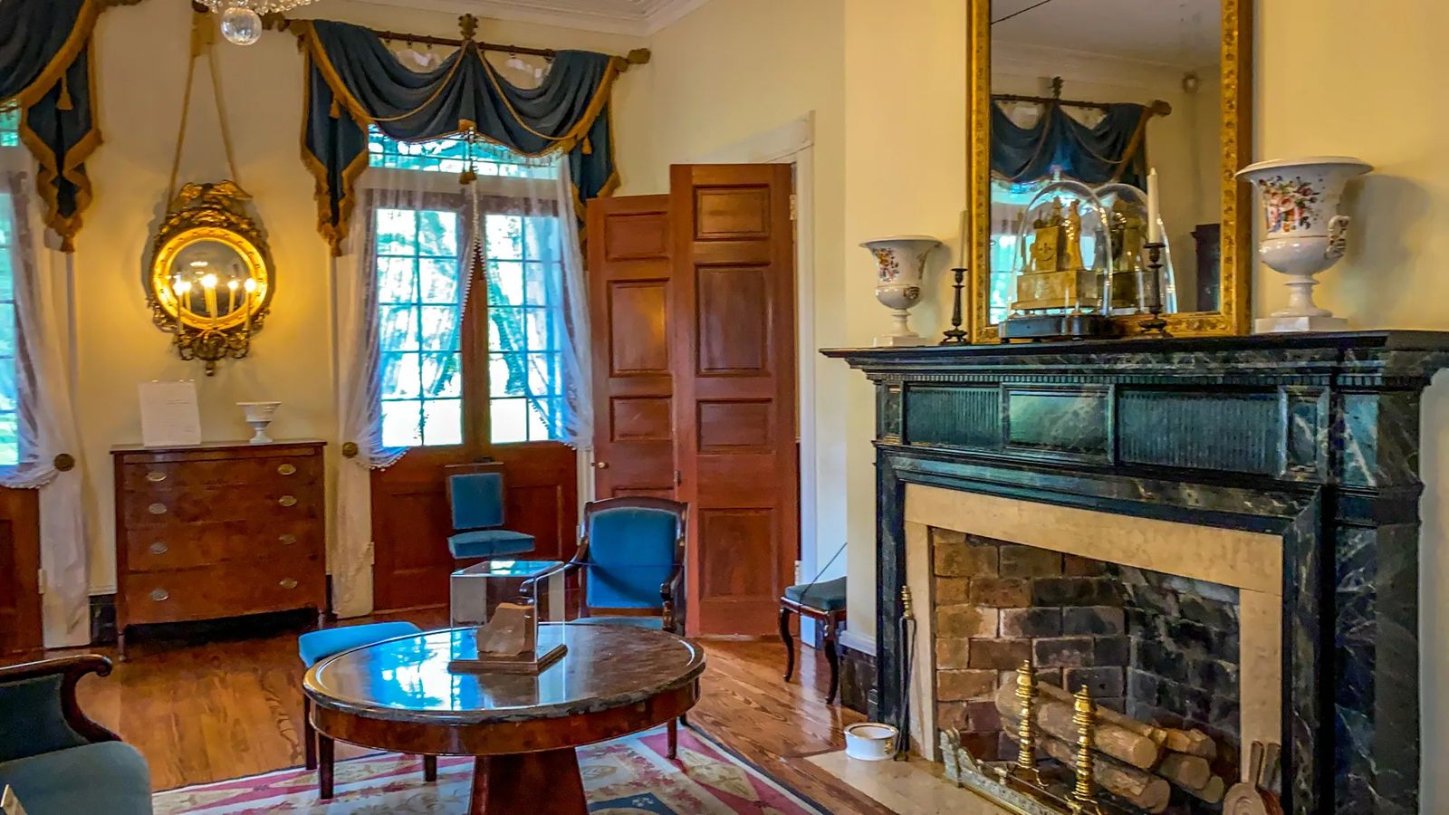 18th century period pieces with decorated windows and fake marble fireplace