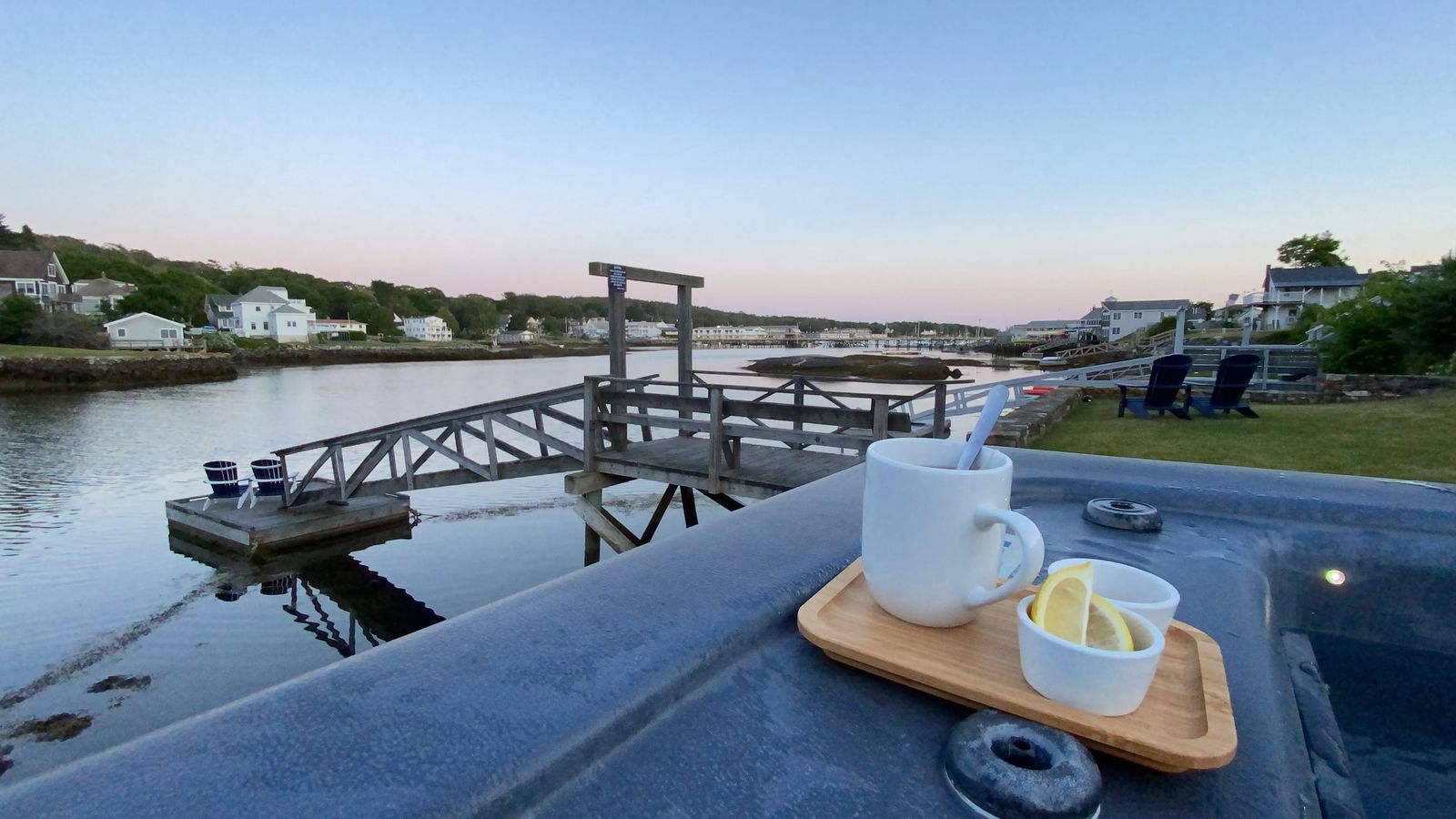 Sunset overlooking Boothbay with a tray of Tea resting on the edge of a hot tub