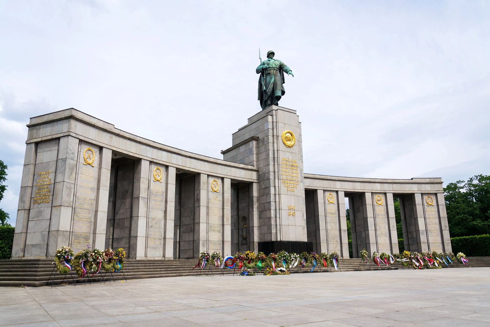 backpacking Eastern Europe 12 hours in berlin and what to see. Picture of grey soviet memorial with wreaths lain at the base