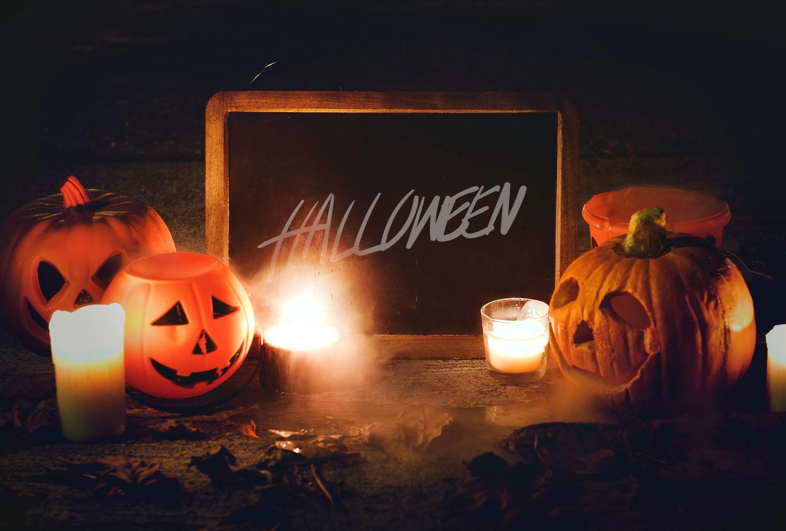 halloween sign on chalkbaord, with candles and pumpkins