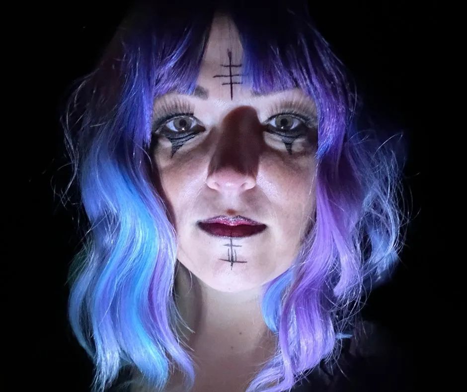 Janiel with blue and purple wig with runes painted on face 