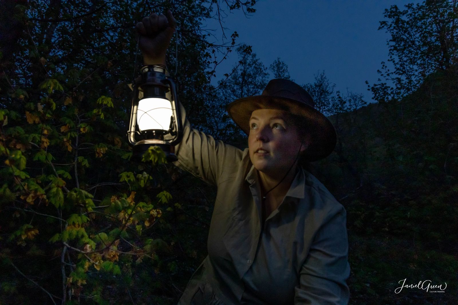 Janiel holding up lantern in spooky forest, rules of camping in utah