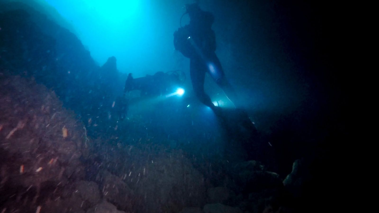 scuba diving in a cave with flashlights