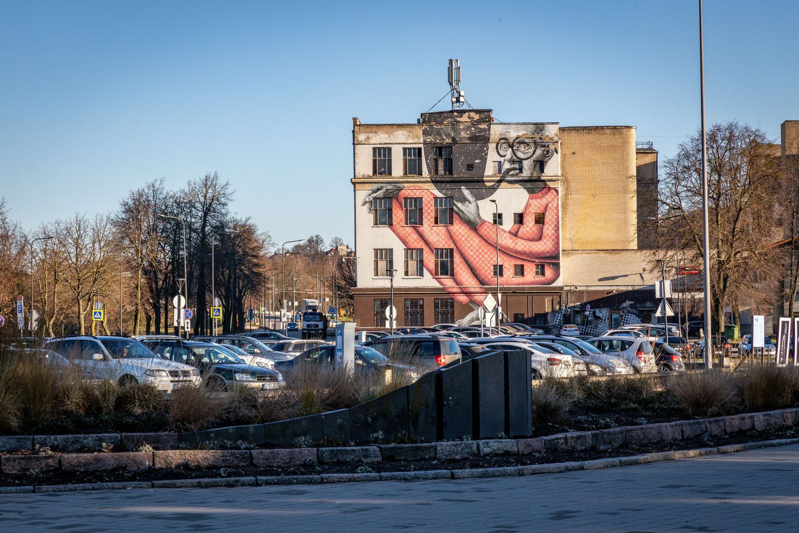 Things to do in Kaunas - street art of Old Man smoking pipe as big as him 