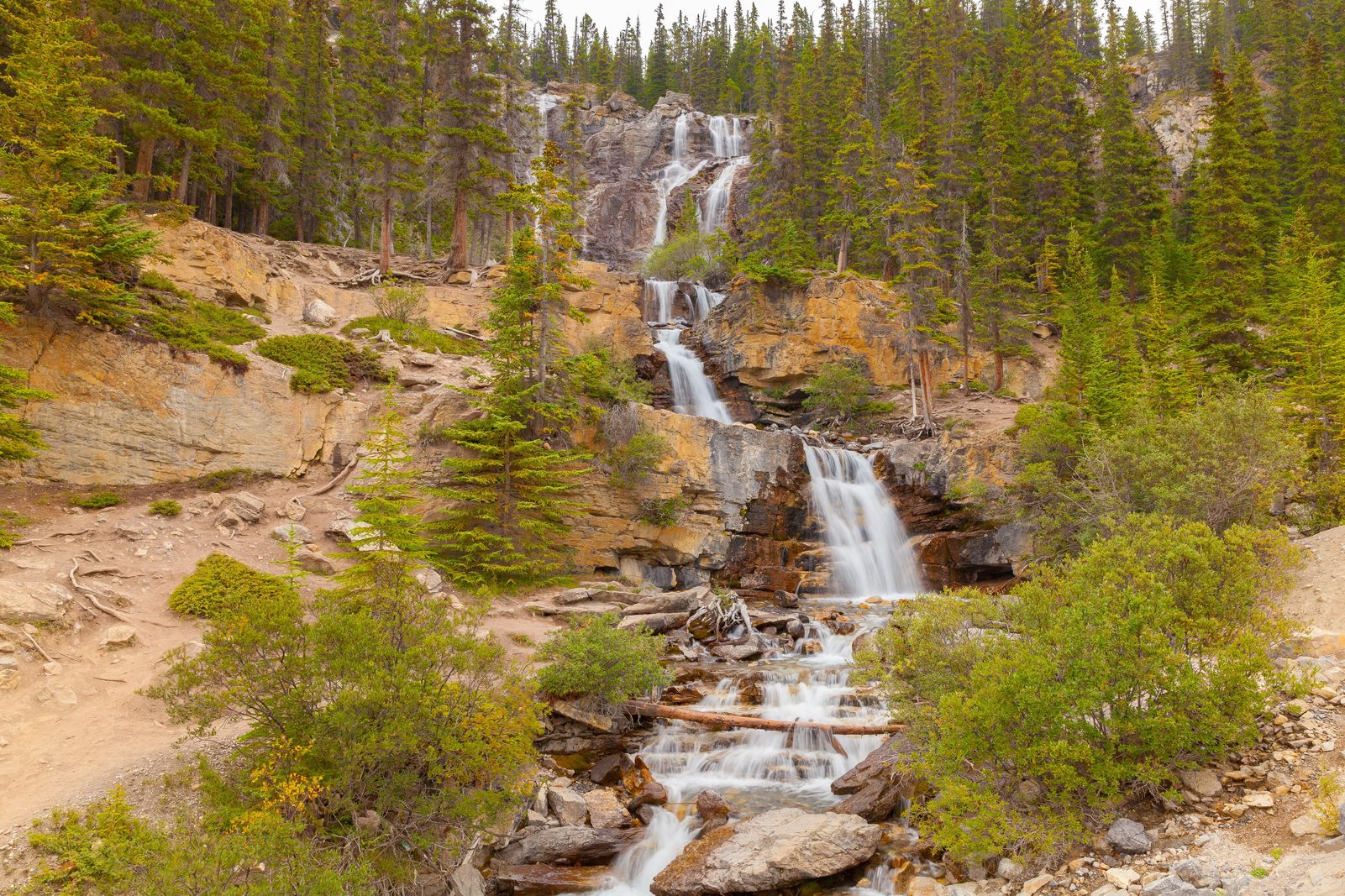 multiple levels of water cascading down a mountainside with a soft appearance to the water