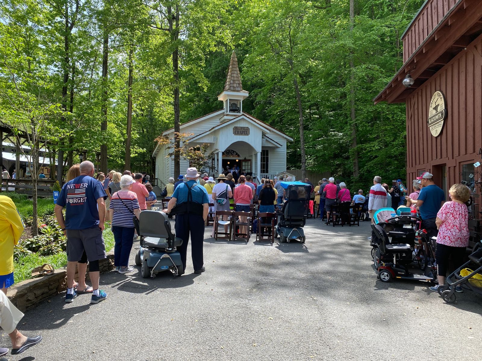 a group gathers for church sermon outisde an 1800's style white church